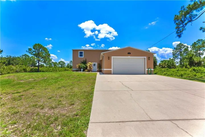 View of front of house with a garage and a front lawn