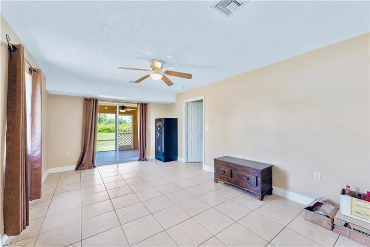 Tiled empty room featuring a textured ceiling and ceiling fan