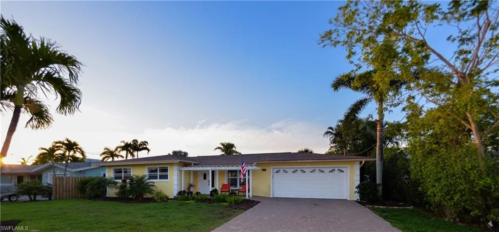 Single story home featuring a lawn and a garage