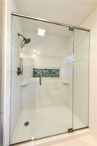 Glass and tile shower with shelves and flexible shower wand