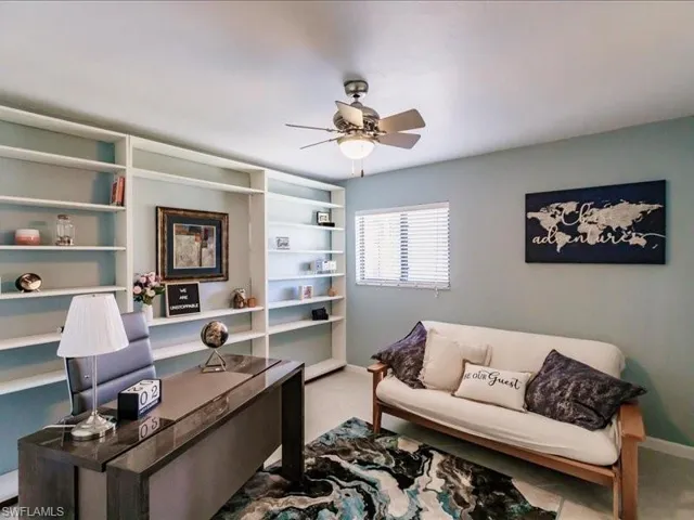 Carpeted home office featuring ceiling fan