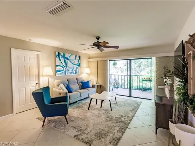 Living room with ceiling fan and light tile flooring