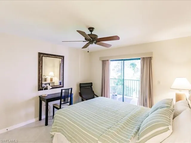 Tiled bedroom featuring ceiling fan and access to exterior