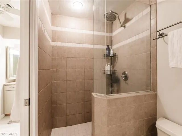 Bathroom featuring tiled shower and toilet