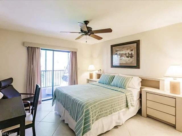 Tiled bedroom featuring ceiling fan and access to exterior