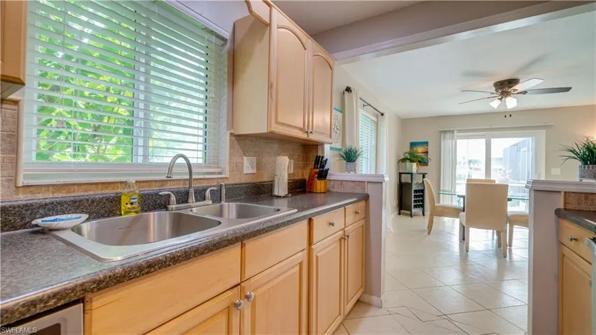 Kitchen featuring a wealth of natural light, light tile patterned flooring, sink, and ceiling fan