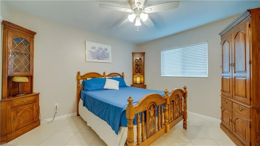 Tiled bedroom featuring ceiling fan