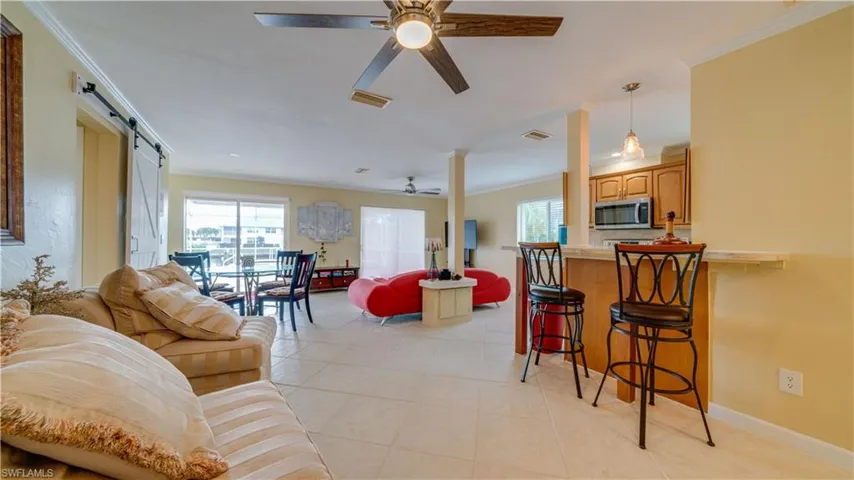 3828 Living room featuring a barn door, ceiling fan, and plenty of natural light