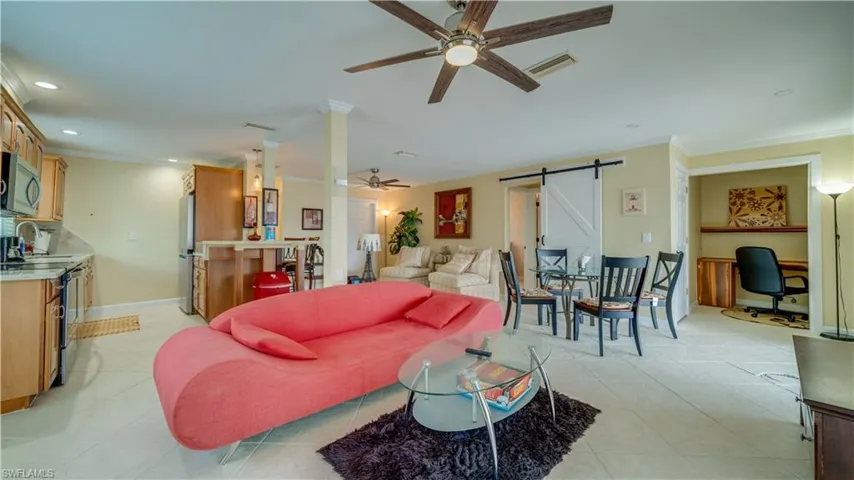 3828 Tiled living room with crown molding, a barn door, ceiling fan, and sink