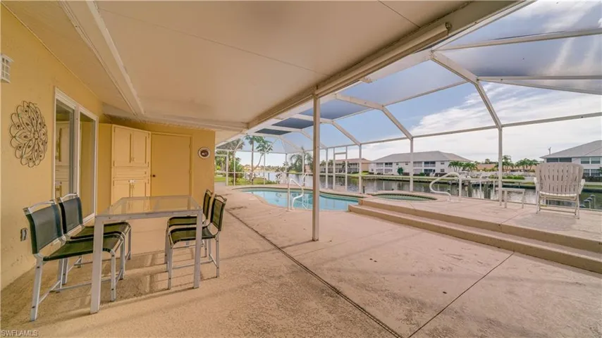 View of swimming pool featuring a water view, a lanai, and a patio
