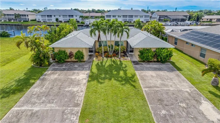 View of front of duplex with a front yard and a water view