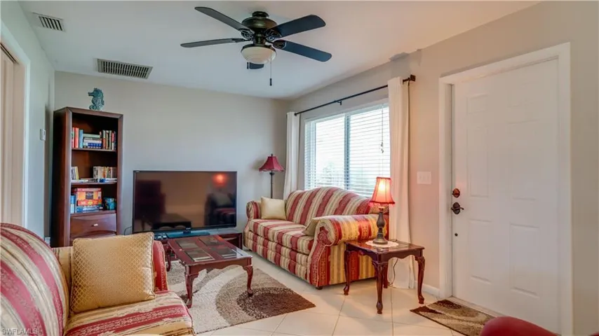 Living room featuring ceiling fan and light tile patterned floors