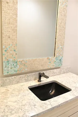 Bathroom featuring vanity and backsplash