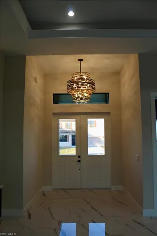 Foyer entrance featuring french doors and a chandelier