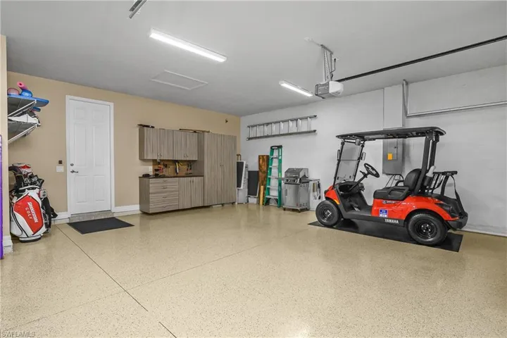 Garage featuring a garage door opener and electric panel