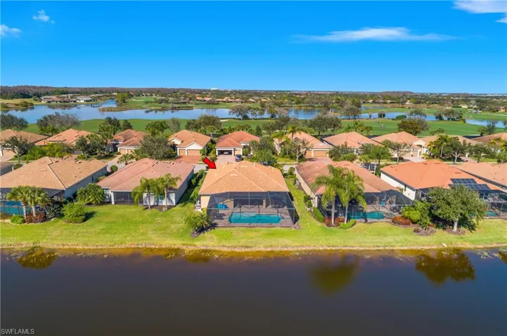Aerial perspective of suburban area featuring a nearby body of water