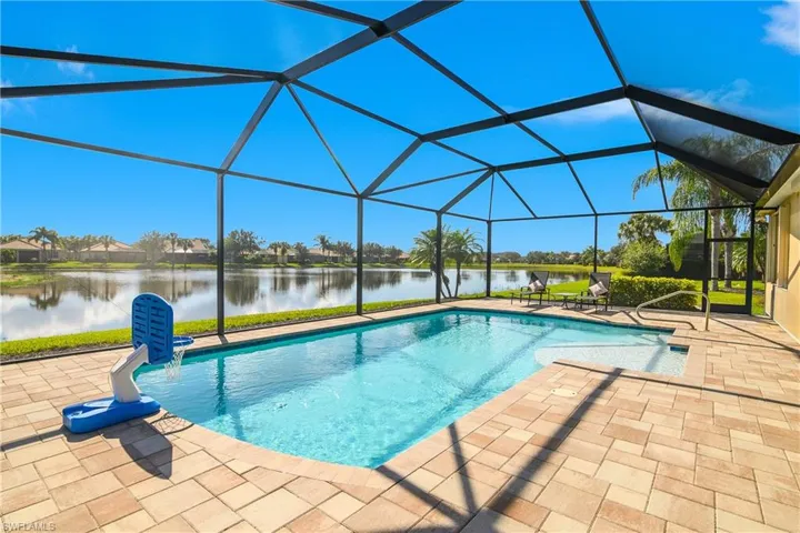 Swimming pool featuring a water view, a sunroom, a lanai, a patio, and a residential view
