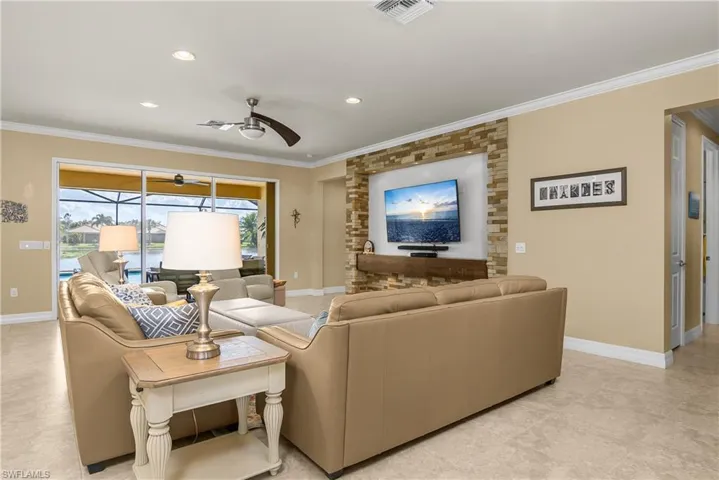 Living area with ceiling fan, ornamental molding, and recessed lighting