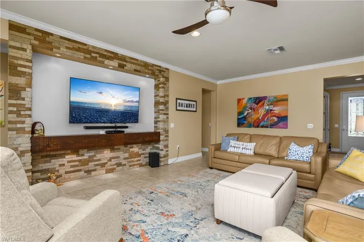 Living area featuring ceiling fan, ornamental molding, recessed lighting, and tile patterned flooring
