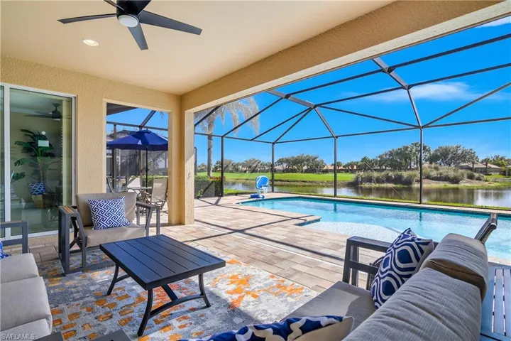 Swimming pool featuring a patio area, a sunroom, a lanai, and a water view