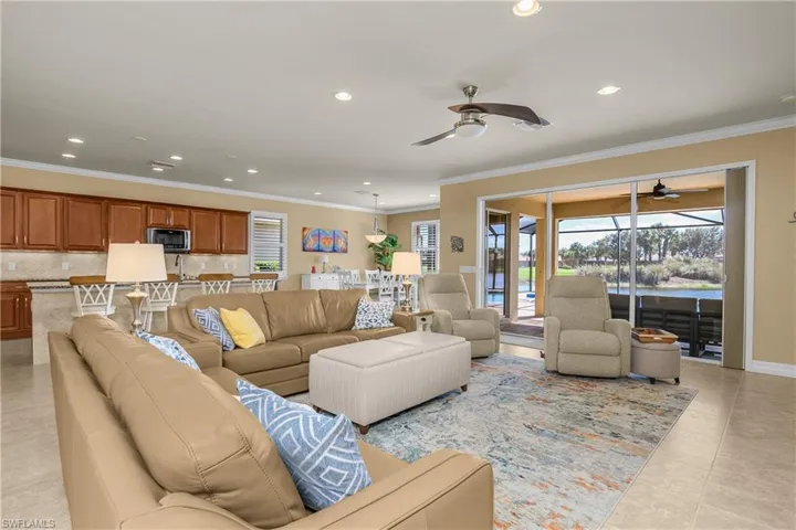 Living room with recessed lighting, ornamental molding, a ceiling fan, and light tile patterned flooring