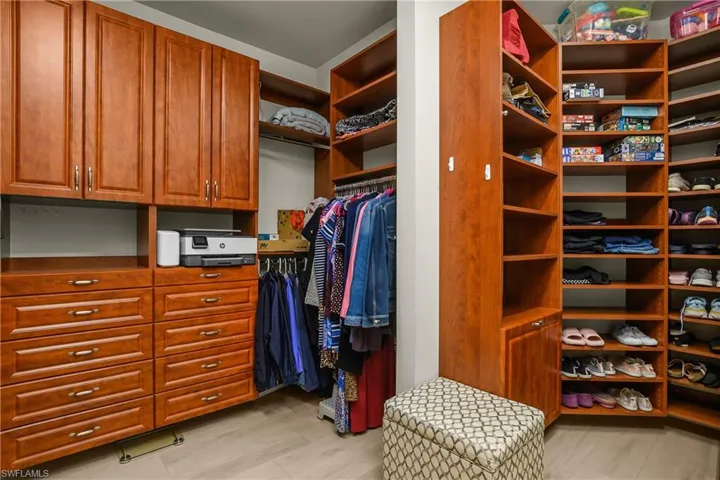 Walk in closet with light wood-style floors