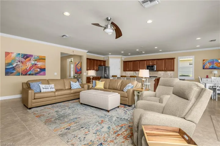 Living room featuring ceiling fan, ornamental molding, recessed lighting, and light tile patterned flooring