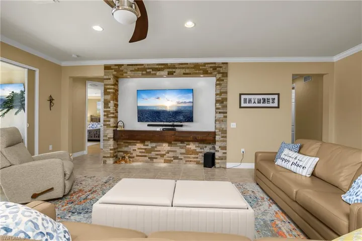 Living room featuring crown molding and ceiling fan