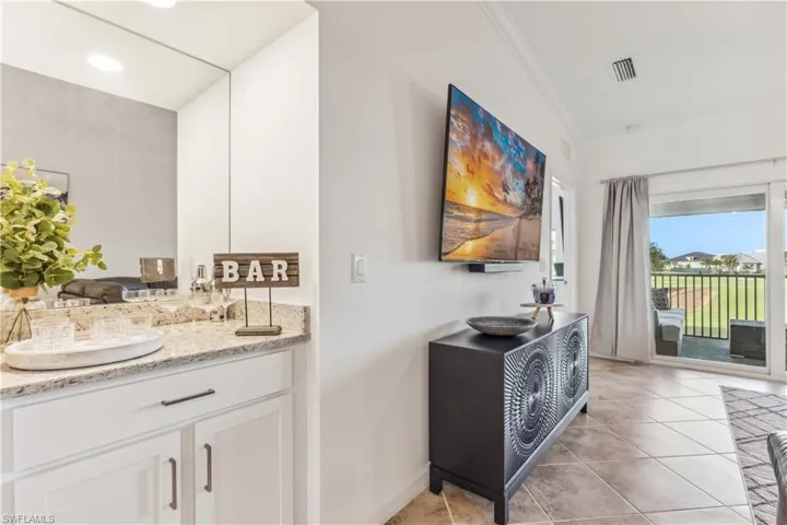 Bathroom featuring crown molding, tile flooring, and vanity