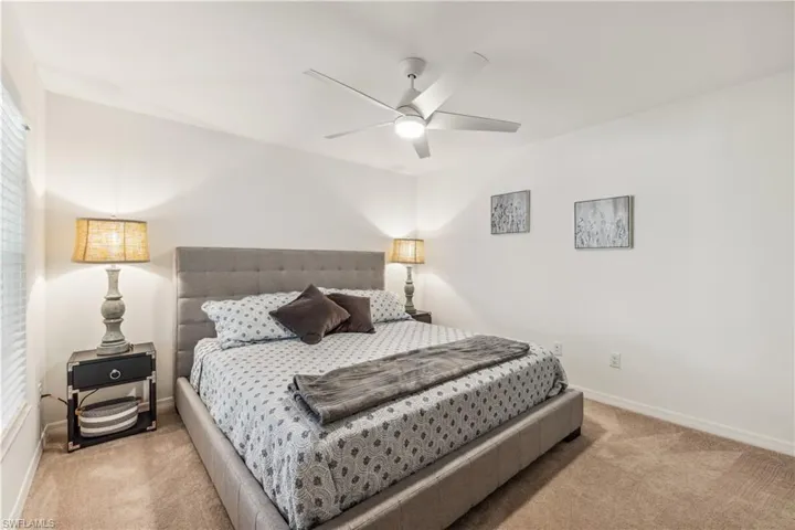 Carpeted bedroom featuring ceiling fan