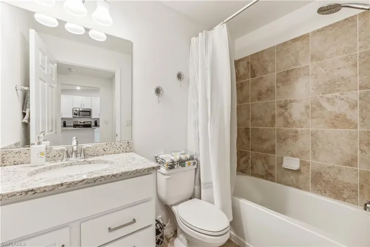 Full bathroom featuring oversized vanity, toilet, and shower / tub combo with curtain