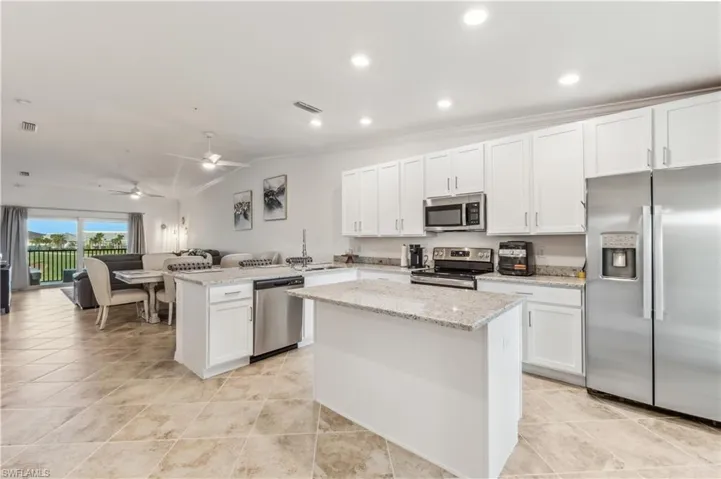 Kitchen featuring kitchen peninsula, white cabinetry, ceiling fan, and stainless steel appliances