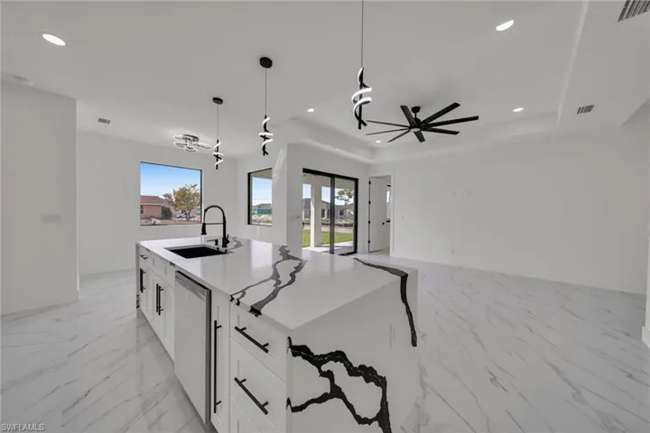 Kitchen featuring white cabinets, a kitchen island with sink, healthy amount of natural light, and open floor plan