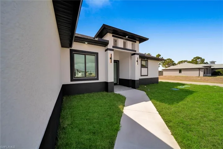 View of front facade with a front lawn and stucco siding