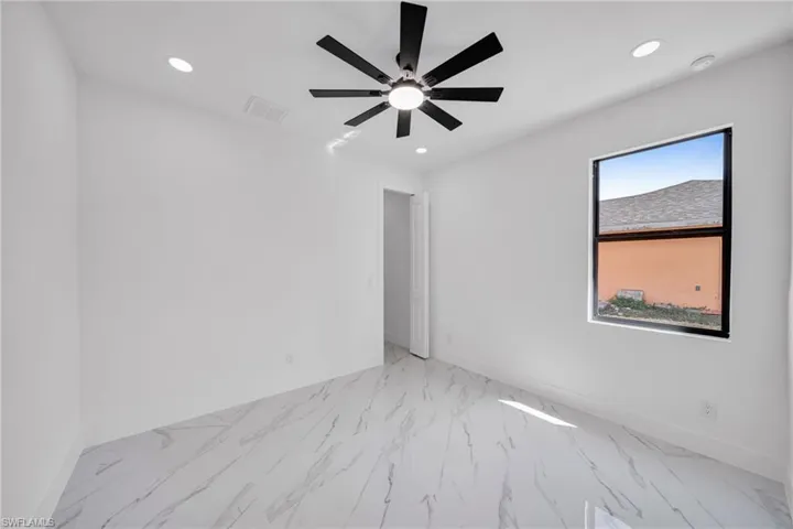 Unfurnished room with recessed lighting, light marble finish flooring, and ceiling fan