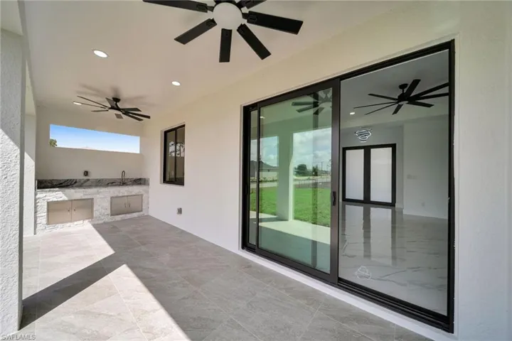 View of patio with exterior kitchen and ceiling fan