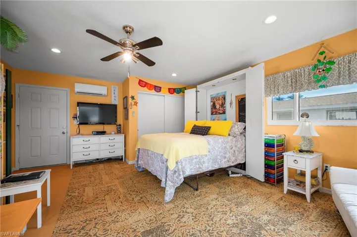 Bedroom featuring a closet, a ceiling fan, and a wall mounted mini split