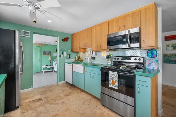 Kitchen featuring stainless steel appliances, ceiling fan, decorative backsplash, and recessed lighting