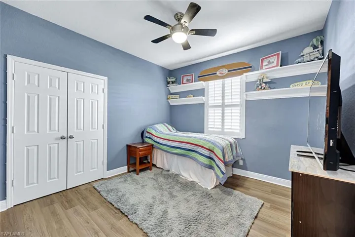 Guest Bedroom 2 featuring light wood-style floors, ceiling fan, and a closet