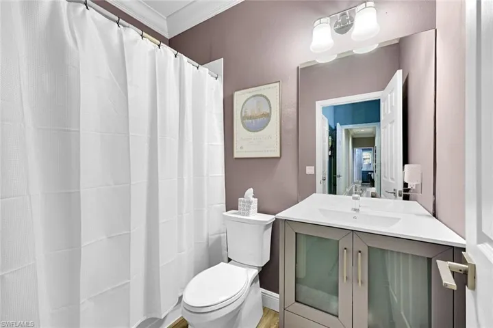 Full bath with a shower with curtain, vanity, and crown molding