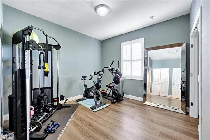 Guest Bedroom 1 is being used as a Workout room with light wood-style floors