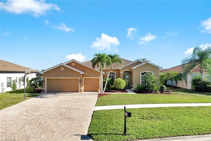 View of front facade featuring stucco siding, decorative driveway, a garage, and a front lawn
