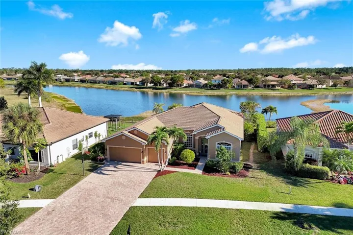 View of front of home featuring a front yard, a water view, a garage, driveway, and a residential view