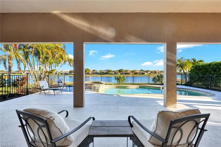 Fenced backyard featuring a patio, a water view, a pool with connected hot tub, and a residential view