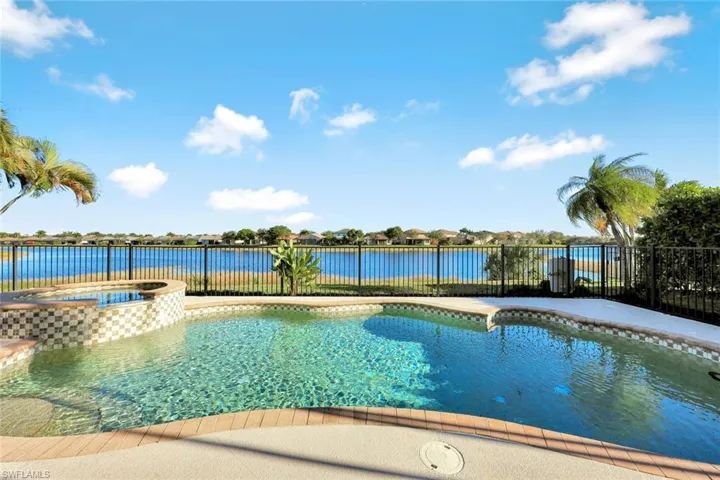 View of swimming pool featuring a pool with connected hot tub and a water view