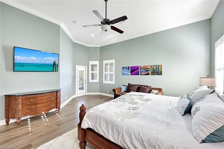 Bedroom with crown molding, ceiling fan, and wood finished floors