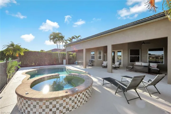 View of pool featuring a patio, a fenced backyard, an outdoor living space, and a pool with connected hot tub