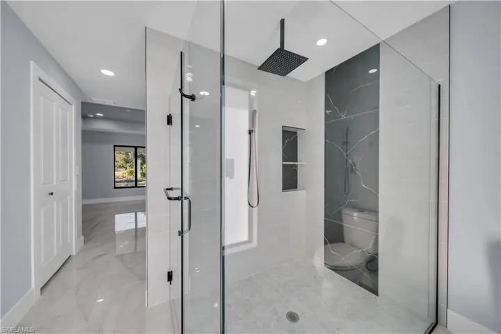 Bathroom featuring a stall shower, recessed lighting, and marble finish flooring