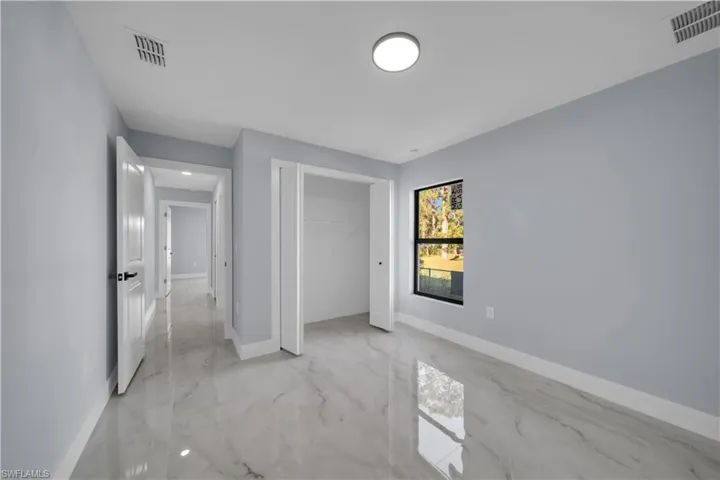 Unfurnished bedroom with light marble finish floors and a closet