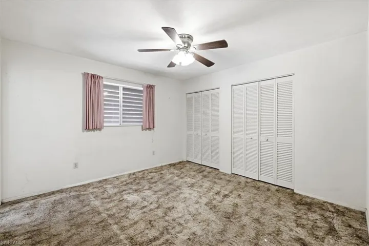 Unfurnished bedroom featuring two closets, carpet flooring, and a ceiling fan